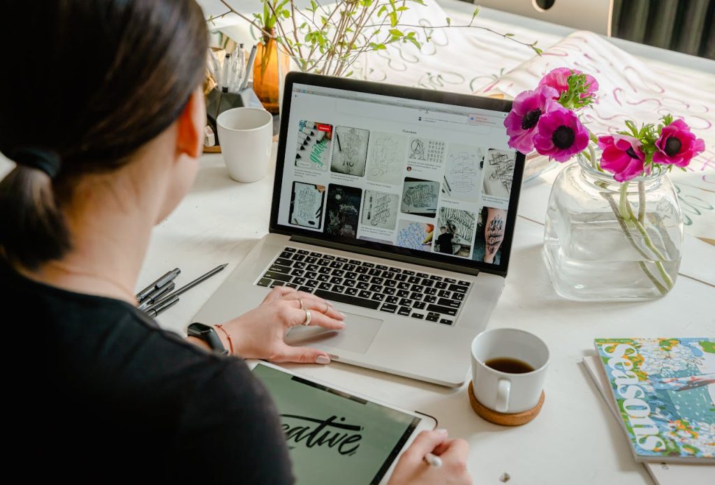 photo-of-person-using-laptop-for-graphic-designs-4348404 Woman in a creative workspace using a laptop and tablet for calligraphy. Artistic and tech-driven environment.